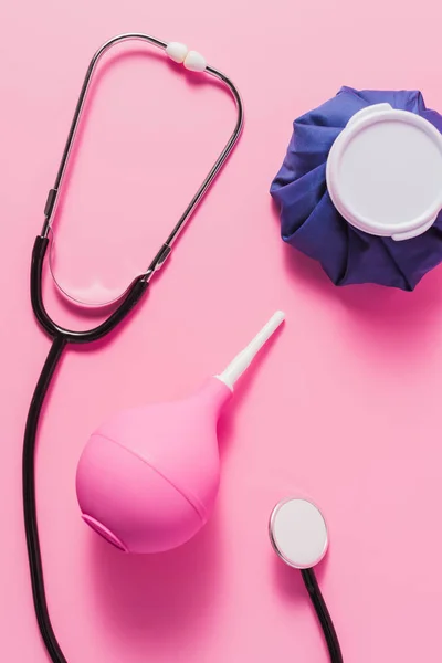 Vista superior de varios instrumentos médicos en la superficie rosa - foto de stock