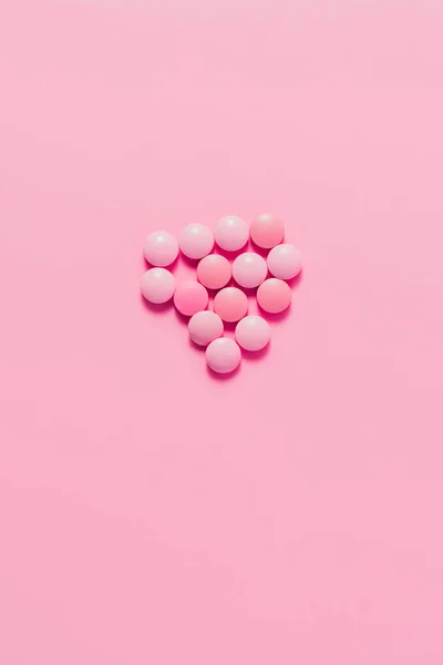 Вид зверху на купу рожевих таблеток на рожевій поверхні — стокове фото