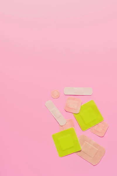 Top view of various adhesive bandages on pink tabletop — Stock Photo