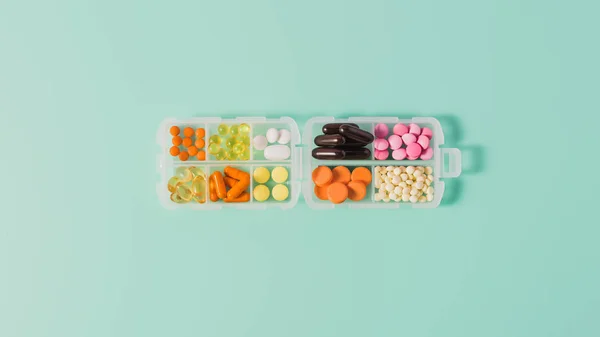 Top view of plastic case with various sorted pills on blue — Stock Photo