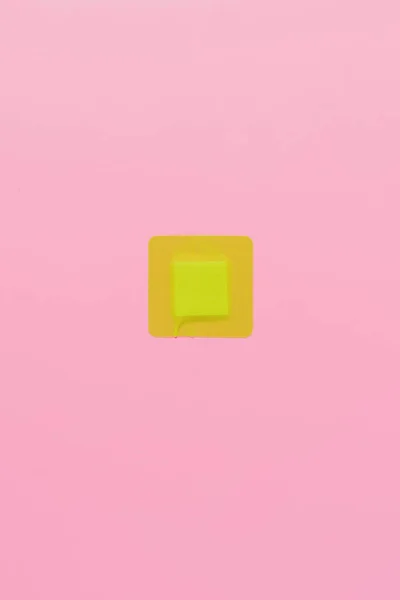 Draufsicht auf grüne quadratische Klebebinde auf rosa — Stockfoto