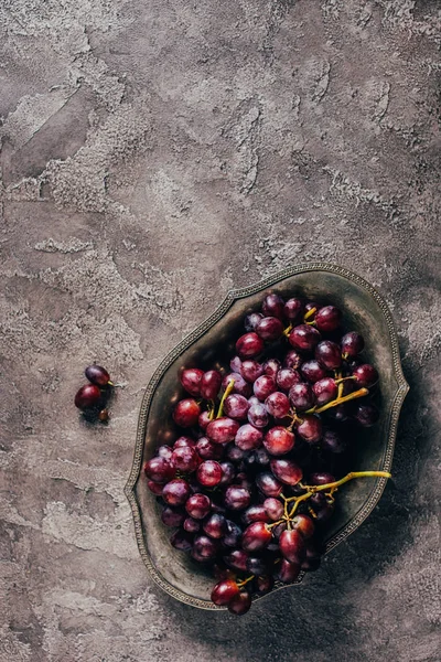 Vista superior de las uvas frescas de jugo maduro en el plato vintage - foto de stock