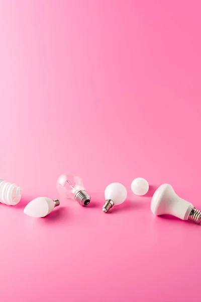 Varios tipos de bombillas sobre fondo rosa - foto de stock