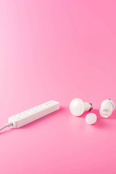 Close-up view of socket outlet and various light bulbs on pink — Stock Photo