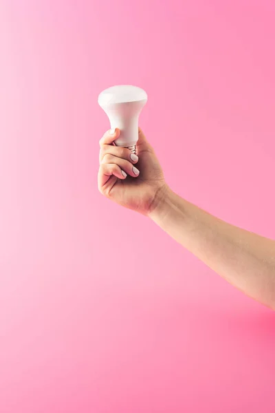 Tiro cortado de pessoa segurando lâmpada isolada em rosa — Fotografia de Stock