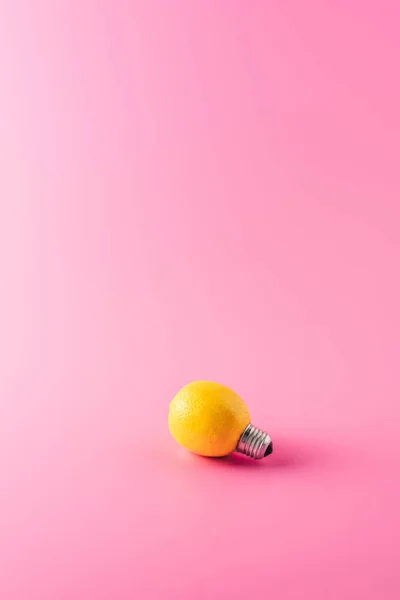 Close-up view of light bulb made of lemon on pink — Stock Photo