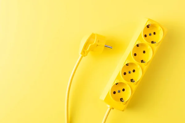 Vista dall'alto di presa di corrente gialla e spina su sfondo giallo — Foto stock