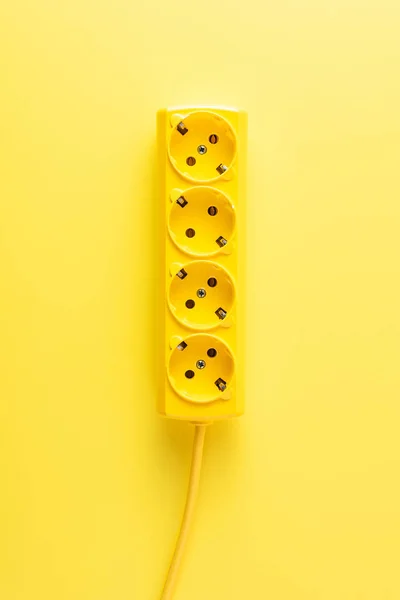 Vista de cerca de la toma de corriente de color amarillo brillante sobre fondo amarillo - foto de stock