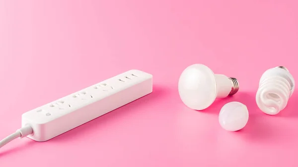 Close-up view of various light bulbs and socket outlet on pink — Stock Photo