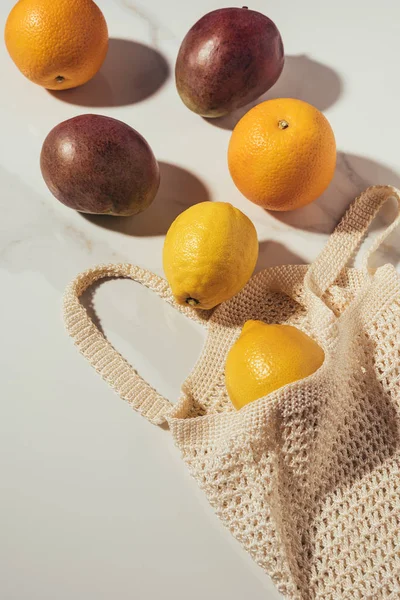 Vista dall'alto di borsa stringa con frutta tropicale matura fresca su bianco — Foto stock