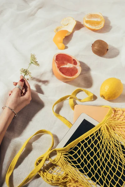 Cropped shot of human hand and string bag with digital tablet and fresh ripe fruits — Stock Photo