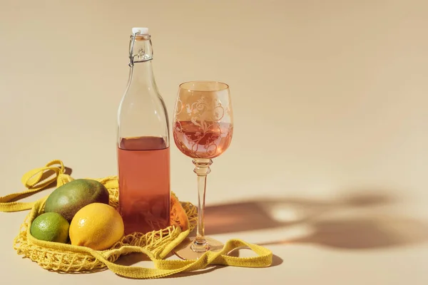 Vista close-up de bebida em vidro e garrafa, saco de cordas e frutas frescas em marrom — Fotografia de Stock