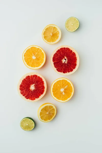 Vista superior de toranja, limão, limão e fatias de laranja, em cinza — Fotografia de Stock