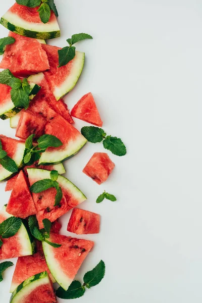 Draufsicht auf frische rote Wassermelonenscheiben und Minzblätter, auf grauem Hintergrund — Stockfoto