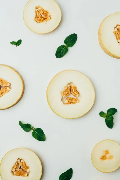 Top view of fresh melon slices and mint leaves, on grey background — Stock Photo