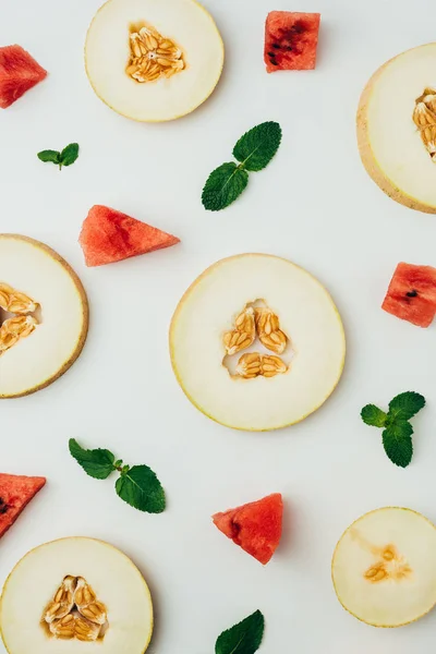 Top view of fresh melon and watermelon slices with mint leaves, on grey background — Stock Photo