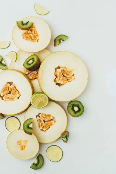 Top view of organic melon, lime and kiwi slices, on grey background — Stock Photo