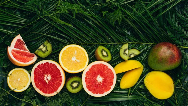 Top view of organic tropical fruits on palm leaves — Stock Photo