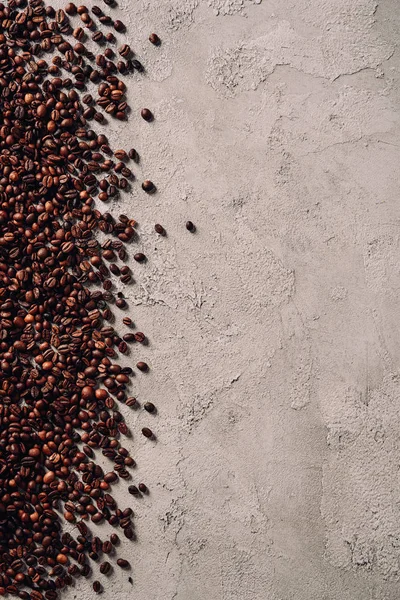Blick von oben auf verschüttete Kaffeebohnen auf Betonfläche — Stockfoto