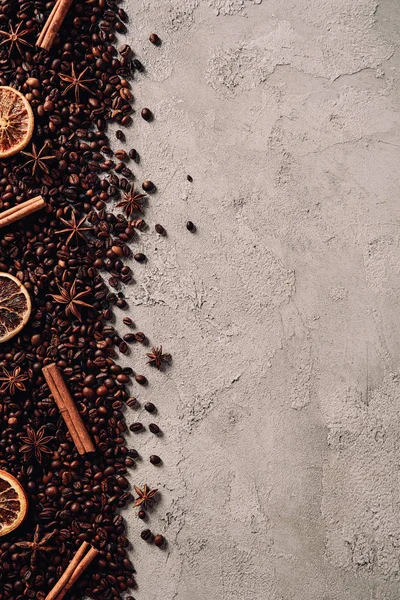 Top view of spilled coffee beans with various spices on concrete surface — Stock Photo