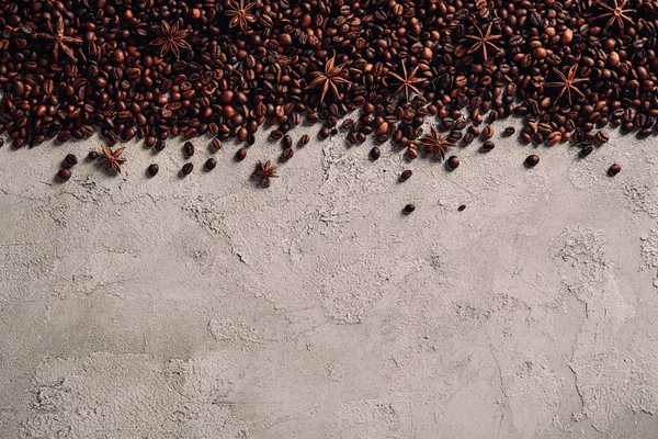 Vue de dessus des grains de café renversés avec anis sur la surface du béton — Photo de stock