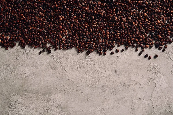 Vue de dessus des grains de café renversés sur la table en béton — Photo de stock