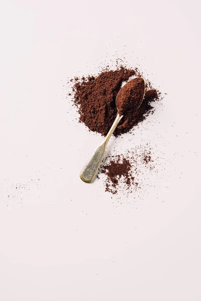 Top view of vintage spoon with grinded coffee on white surface — Stock Photo