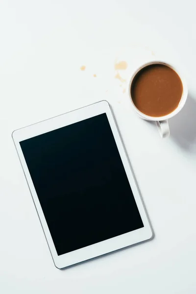 Вид сверху на чашку кофе и планшет на белой поверхности — стоковое фото