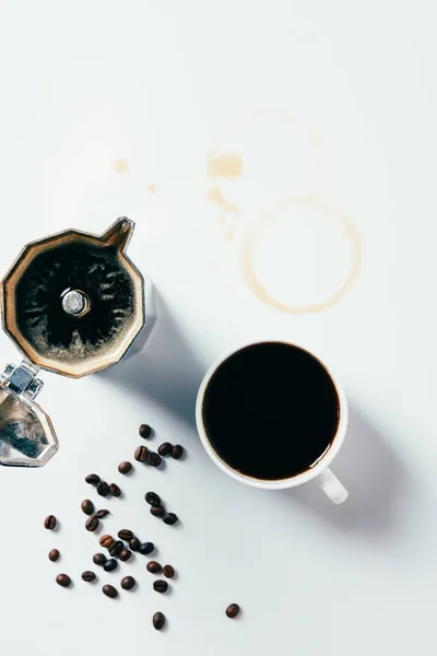 Вид сверху на чашку черного кофе с кастрюлей мочи на мускусной белой поверхности — стоковое фото