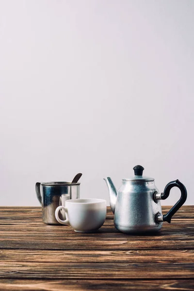 Various cups of coffee with vintage metal pot on rustic wooden table — Stock Photo