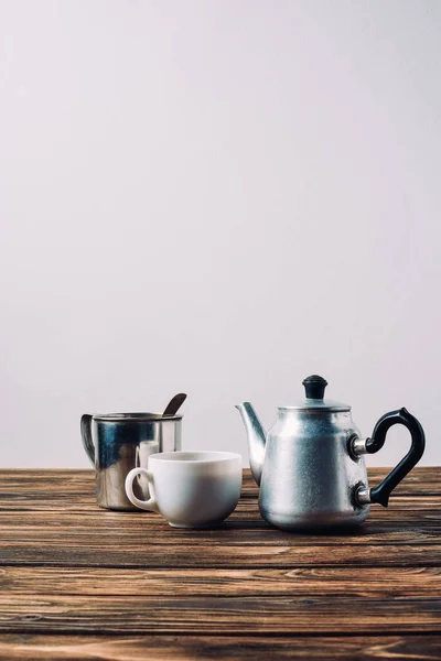 Varias tazas de café con maceta de metal vintage en mesa de madera rústica - foto de stock