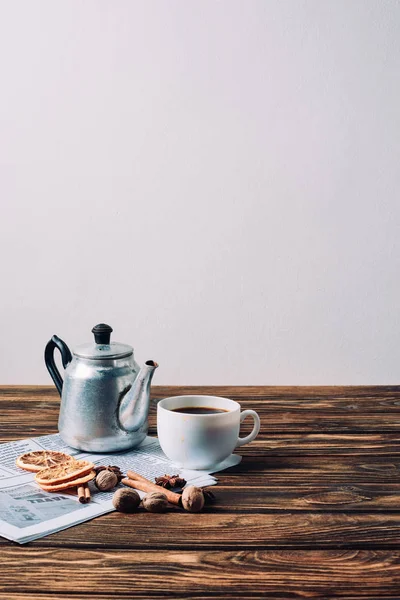 Чашка кави з вінтажним металевим горщиком, печивом та спеціями на сільському дерев'яному столі — стокове фото