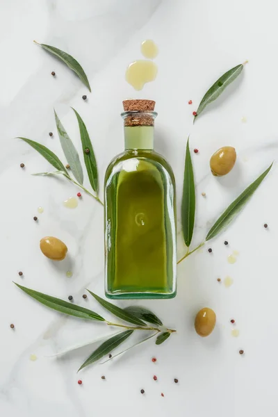 Food styling of olive oil bottle and olives on marble table — Stock Photo