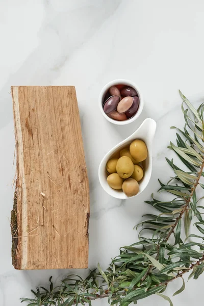 Top view of ingredients for olive oil preparation and log on marble table — Stock Photo