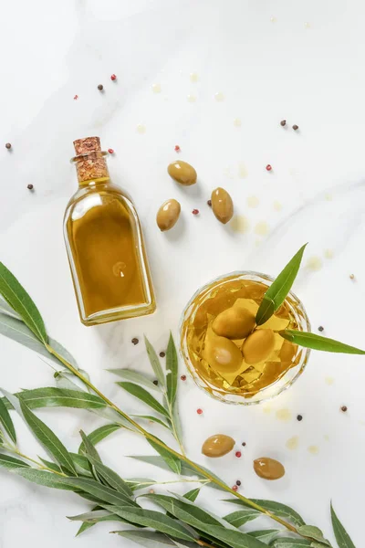 Draufsicht auf Flasche und Glas mit Olivenöl auf Marmortisch — Stockfoto