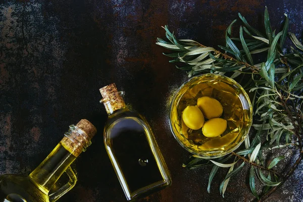 Top view of glass jars with olive oil on shabby surface — Stock Photo