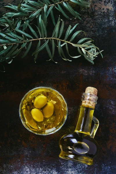 Top view of olive oil in glass and jar on shabby surface — Stock Photo