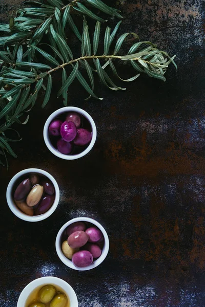 Vista superior de las aceitunas para la preparación de aceite en cuencos en superficie de mala calidad - foto de stock