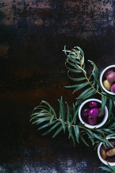 Vue de dessus des olives savoureuses pour la préparation de l'huile dans des bols sur une surface minable — Photo de stock