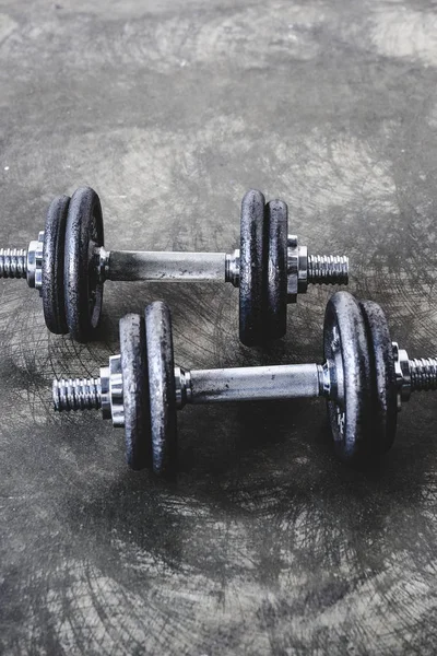 Close-up shot of adjustable dumbbells on concrete surface — Stock Photo