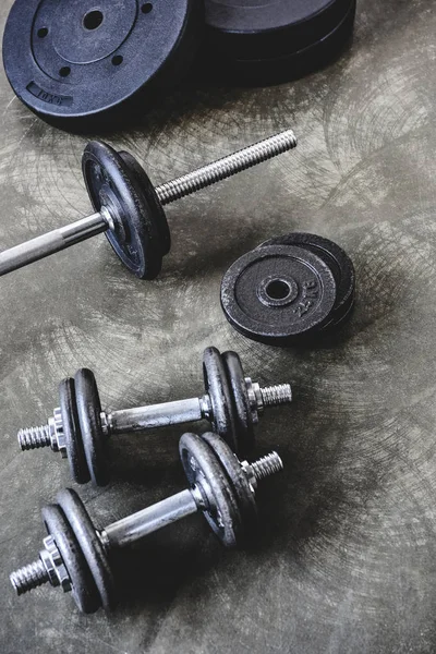 Vista de ángulo alto de varios equipos de gimnasio en la superficie de hormigón - foto de stock