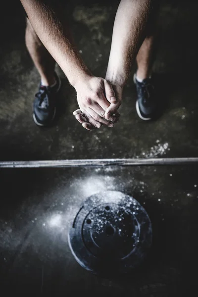 Обрезанный снимок силового лифтера, закрывающего руки в тальке перед тренировкой — стоковое фото