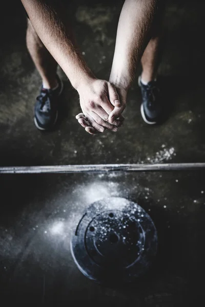 Abgeschnittener Schuss eines Krafthebers, der die Hände vor dem Training mit Talkum bedeckt — Stockfoto