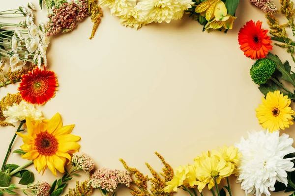 Plano con varios arreglos de flores hermosas con espacio en blanco en el centro sobre fondo beige - foto de stock