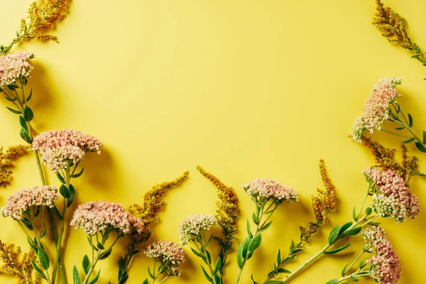 Flat lay com belo arranjo de flores silvestres no fundo amarelo — Fotografia de Stock