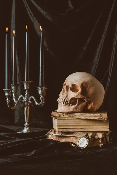 Velas de Halloween preto, crânio e livros antigos sobre pano preto — Fotografia de Stock