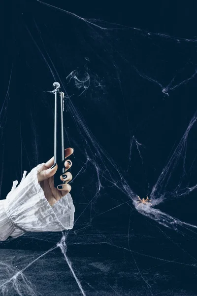 Обрезанный вид мистической женщины, держащей дымчатую свечу в темноте с паутиной — стоковое фото