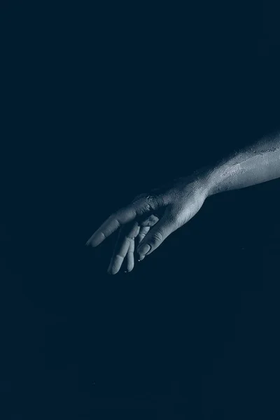 Vista recortada de la mano demonio negro, aislado en negro - foto de stock