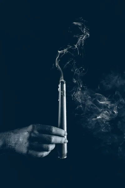 Cropped view of black hand with smoky candle, isolated on black — Stock Photo