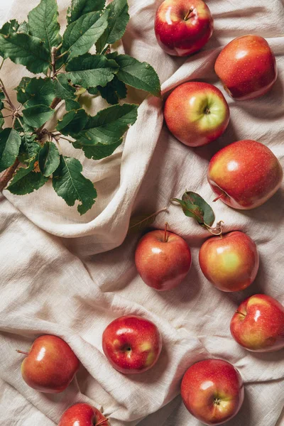 Vista superior de manzanas frescas con hojas de manzano sobre tela para saquear - foto de stock